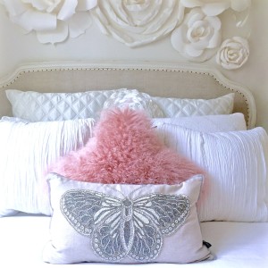 white shabby chic bedroom with blush furry pillow and throw..