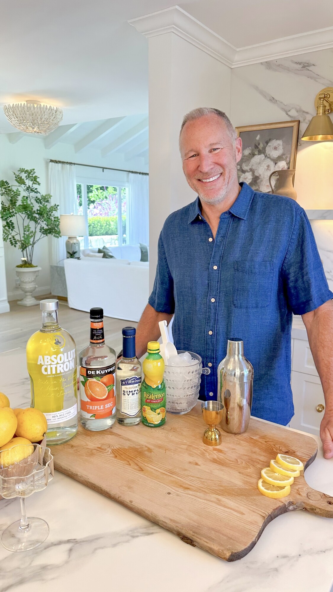 Jeff smiling in kitchen with lemon drop setup, liquor on cutting board
